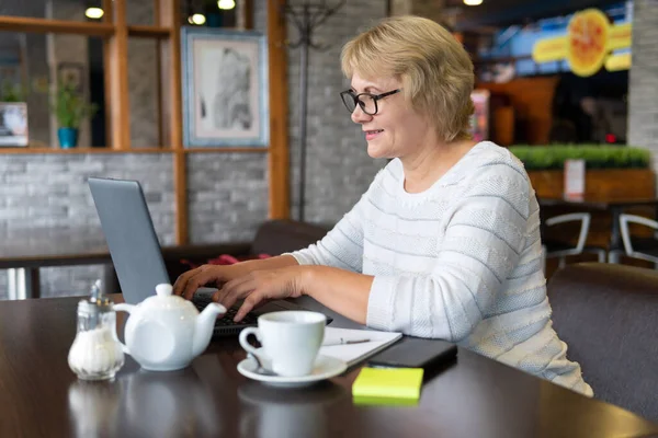 Una Mujer Trabaja Una Laptop Café Una Mujer Mediana Edad — Foto de Stock