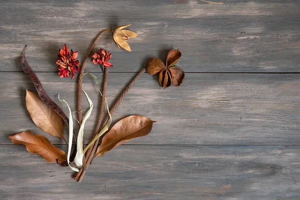 Ahşap arka planda kurumuş renkli çiçekler. Uzayı kopyala Romantik çiçekler. Metin ve tasarım için yer. Tebrik kartı. Düz yatış, üst görünüm.