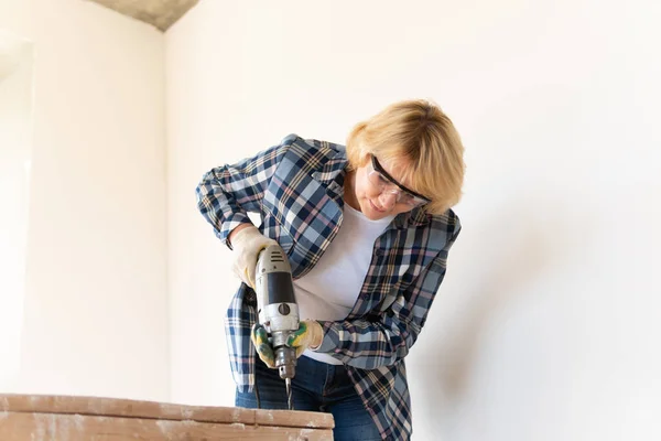 Eine Bauarbeiterin Bohrt Eine Wand Eine Frau Mittleren Alters Repariert — Stockfoto