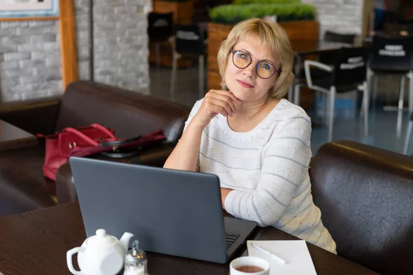 Una Mujer Trabaja Una Laptop Café Mujer Mediana Edad Bebiendo — Foto de Stock