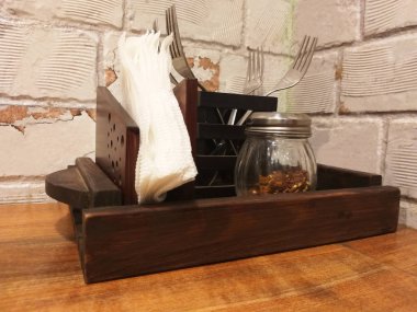 Çatallar ve kağıt mendiller ahşap bir kabın içine konmuş..