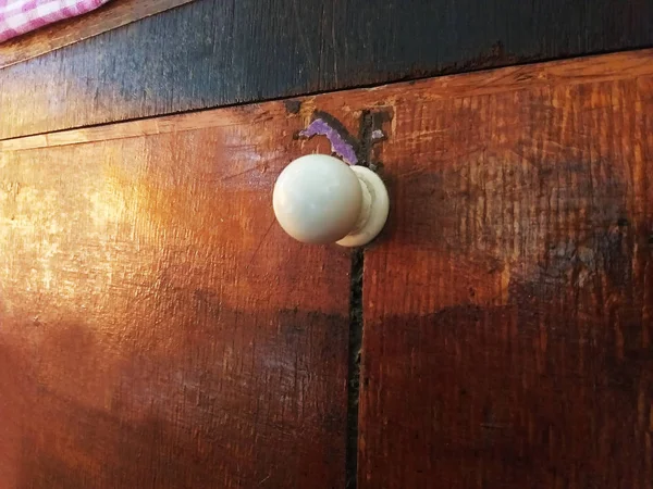 A close up shot of a door knob of a cabinet.