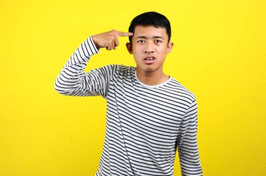 Genç Asyalı adam parmak kaldırarak delilik yapıyor. 