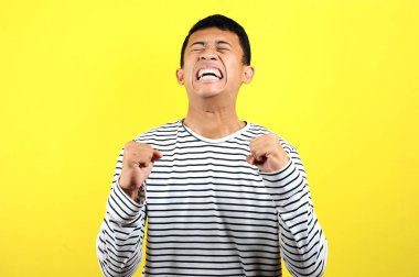 Asyalı genç adam kızgın, sinirli ve duygusal hareketler yapıyor.