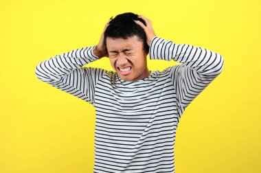 Kafasını tutan hayal kırıklığına uğramış bir adam. Genç Asyalı adam en büyüğünü yapıyor.