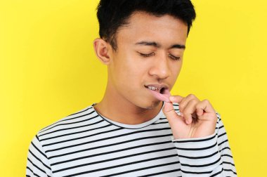Young Asian man showing ulcer or blister in his mouth at the camera, clipart
