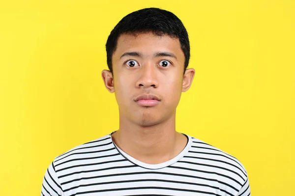 Foarte serios tânăr asiatic om uita-te la camera izolat pe galben — Fotografie, imagine de stoc