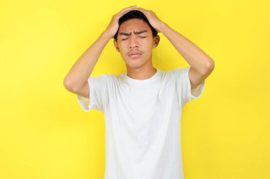 Kafasını tutan hayal kırıklığına uğramış bir adam. Asyalı genç bir adam, hayal kırıklığına uğramış bir adamın başıyla hareket ediyor.