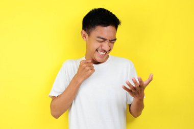 Asyalı genç adam mutlu ve heyecanlı kazanan jestler yapıyor. Başarılı ve kutlayıcı.
