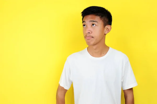 Красивий підліток дивиться на місце для копіювання з білою футболкою, ізольовані на жовтому — стокове фото