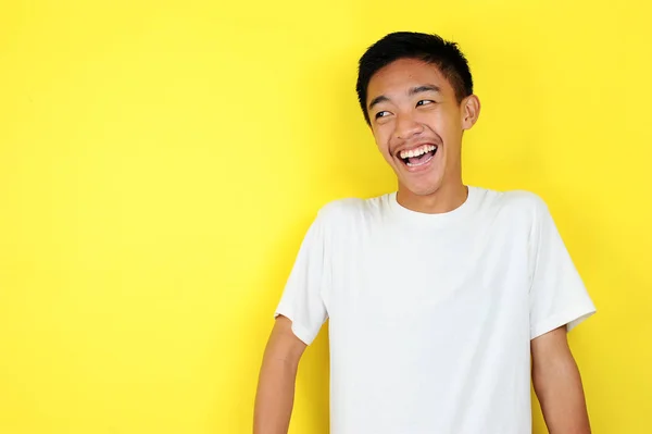 Пристойний молодий азіат посміхається. Зведіть портрет вродливого молодого азіатського чоловіка, який посміхається, дивлячись на копіювальний простір. — стокове фото