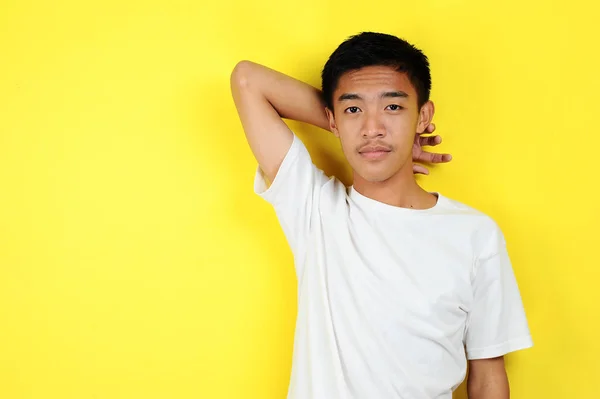 Sarı renkte uzanan kendine güvenen Asyalı genç mutlu. — Stok fotoğraf