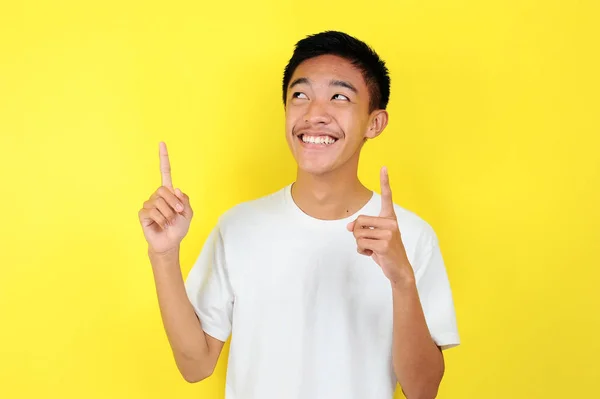 Retrato de un joven asiático inteligente y feliz pensando y mirando hacia arriba. Feliz joven asiático con camiseta blanca pensando y mirando hacia arriba , —  Fotos de Stock