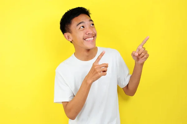 Arkadaş canlısı görünümlü hoş Asyalı beyaz tişörtlü hoş bir erkek fotokopi çekilen yere neşeyle bakıyor. Kendine güvenen işaret — Stok fotoğraf