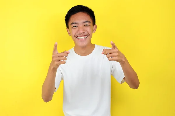 Щасливий молодий азіат усміхається, показуючи на камеру. — стокове фото