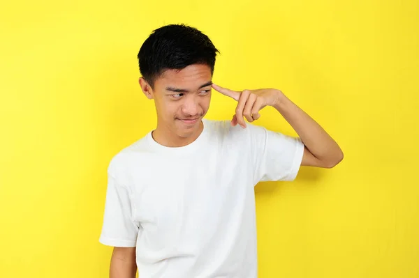 Portrait of smart young Asian man doing thinking gesture. Pria Asia muda yang bahagia memakai kaos putih berpikir dan melihat sisi — Stok Foto