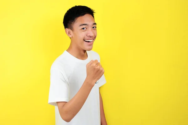 Joven asiático hombre feliz y emocionado expresando gesto ganador. Exitoso y celebrando —  Fotos de Stock