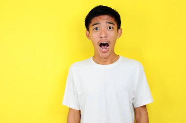 Sarılı beyaz gömlekli Asyalı adamın şok olmuş yüzü.