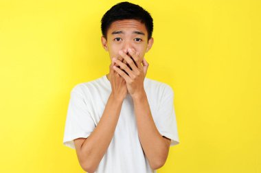 Sarılı beyaz gömlekli Asyalı adamın şok olmuş yüzü.