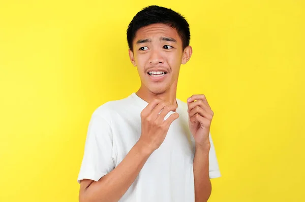 Chockad ansikte asiatisk man i vit skjorta på gul — Stockfoto