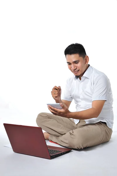 Giovane uomo d'affari asiatico o giovane imprenditore asiatico sedersi sul pavimento bianco che tiene il computer portatile. Eccitato di giovane asiatico freelance . — Foto Stock