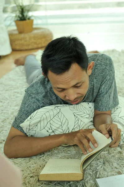 Portret Azjaty czytającego książkę w czytelni — Zdjęcie stockowe