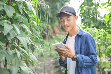 Küçük deftere yazan gülümseyen Asyalı çiftçinin portresi.