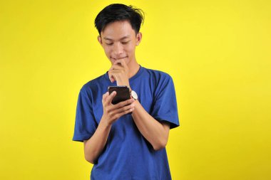 Happy of young good looking Asian man smiling using smartphone