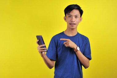 Happy of young good looking Asian man smiling using smartphone