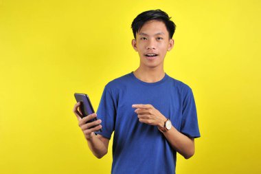 Happy of young good looking Asian man smiling using smartphone