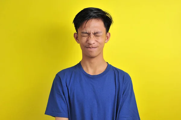 Portrait of young Asian man close his eyes, isolated on yellow — Stockfoto