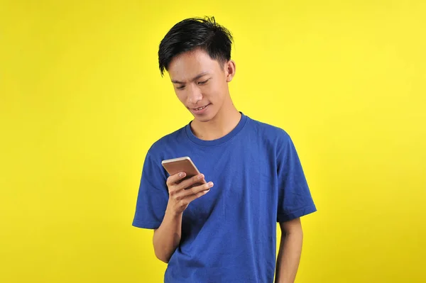 Happy of young good looking Asian man smiling using smartphone — 스톡 사진