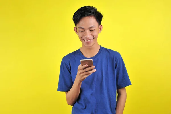 Ευτυχισμένος των νέων όμορφος Ασιάτης χαμογελώντας χρησιμοποιώντας το smartphone — Φωτογραφία Αρχείου