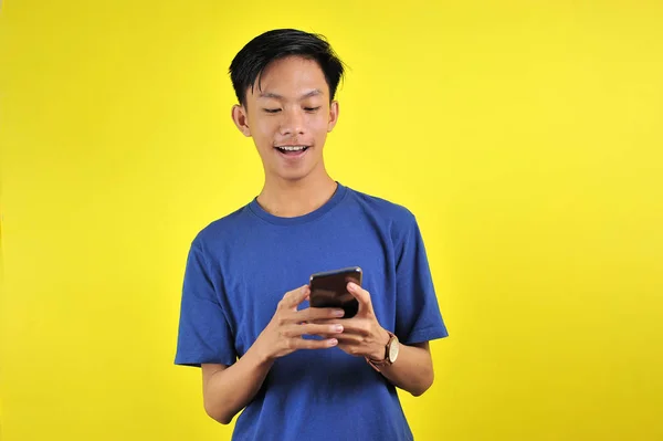 Happy of young good looking Asian man smiling using smartphone — Stockfoto