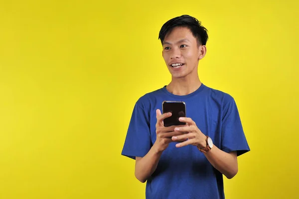 Happy of young good looking Asian man smiling using smartphone — 스톡 사진