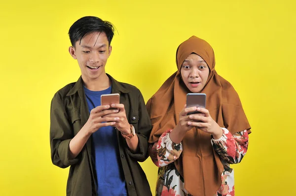 Frau und junger Mann schauen schockiert auf Smartphone-Display — Stockfoto