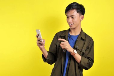 Happy of young good looking Asian man smiling using smartphone