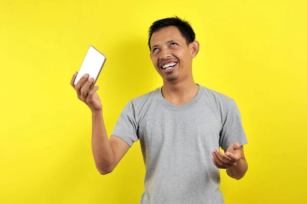 Funny Young Asian man holding smartphone — 스톡 사진