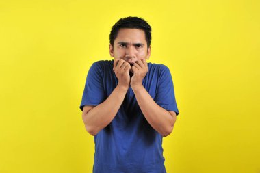 Yakışıklı genç adam korkmuş, stresli ve gergin görünüyor. Elleri ağızdan tırnak yiyor.