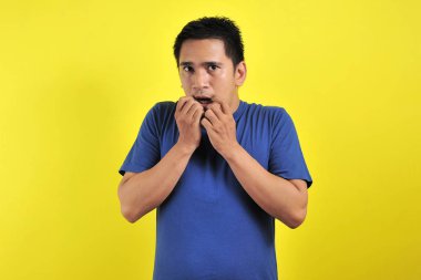 Yakışıklı genç adam korkmuş, stresli ve gergin görünüyor. Elleri ağızdan tırnak yiyor.