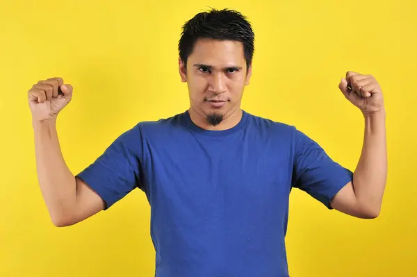 Stilig ung asiatisk man visar muskler, stark gest och visar makt — Stockfoto