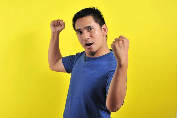 Joven asiático hombre feliz y emocionado expresando el gesto ganador — Foto de Stock