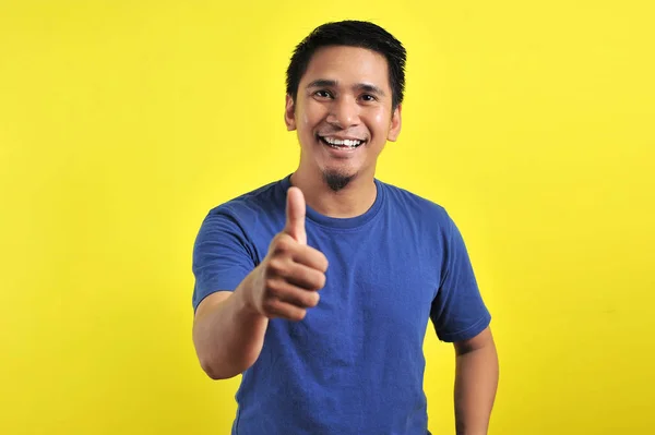 Porträtt av ung asiatisk man skrattar med tummen upp framför kameran — Stockfoto
