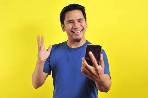 Happy young good looking Asian man smiling using cellphone — 스톡 사진