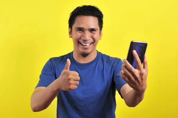 Happy of young good looking Asian man smiling using smartphone — 스톡 사진