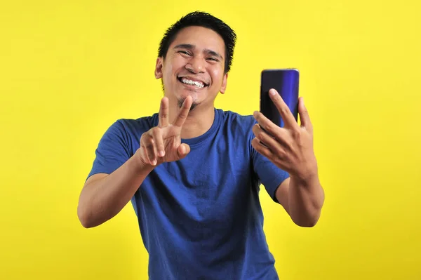 Happy of young good looking Asian man smiling using smartphone — 스톡 사진