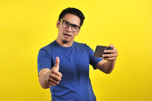 Happy of young good looking Asian man smiling using smartphone