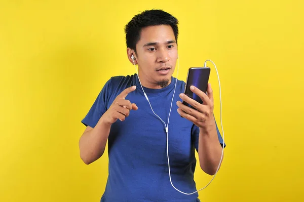 Asian man in casual blue t-shirt wearing headset listening music — 스톡 사진
