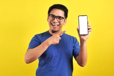 Mutlu Asyalı adam telefon ekranını gösteriyor ve işaret ediyor.