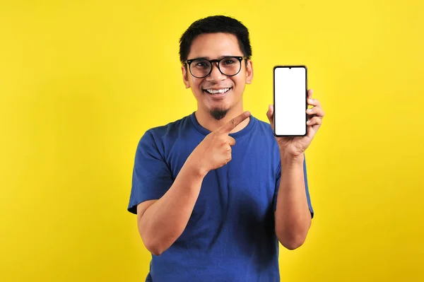 Feliz asiático hombre mostrando una pantalla de teléfono y señalando —  Fotos de Stock